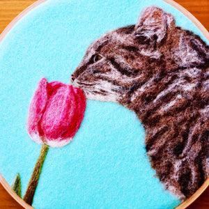 Wool painting of a cat smelling a tulip