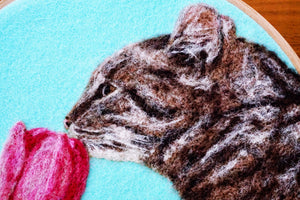 Wool painting of a cat smelling a tulip